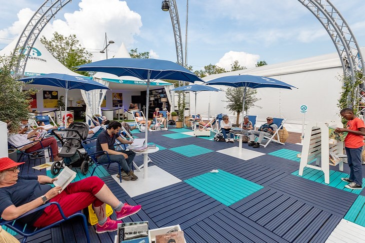 Lire à la plage, une pause entre deux voiliers